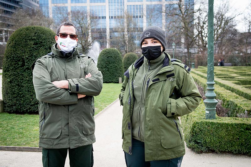 Deux gardiens de parc portant des masques au Jardin Botanique.