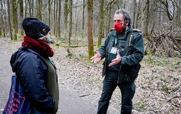 Un garde forestier sensibilise les promeneurs à la préservation de la forêt.