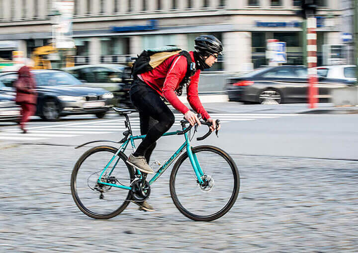 Un homme avec un casque roule vite à vélo dans le centre-ville