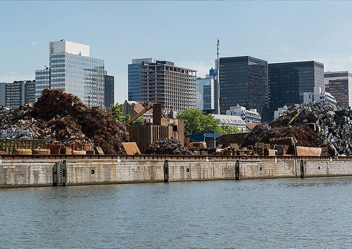 Le canal, des déchets de métaux sur la rive et des immeubles
