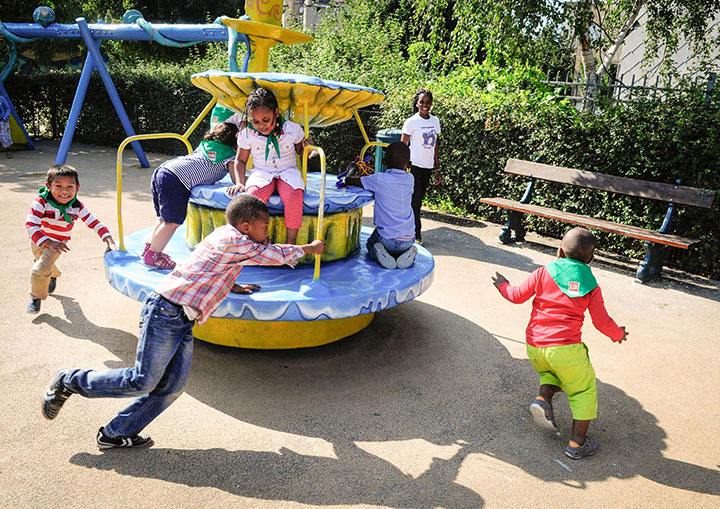 Des enfants jouent dans un espace de jeux extérieur.